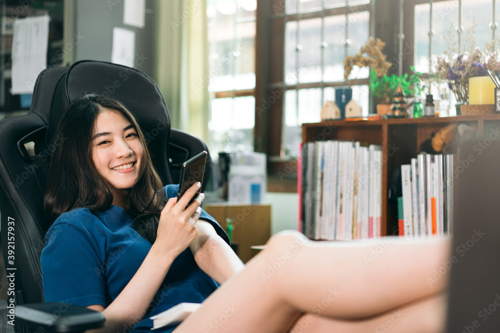 Portrait happy smile young adult freelancer asian woman using mobile phone in workplace space at home.