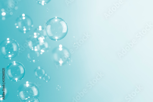 Beautiful shiny soap bubbles float on soft green background with copy space. Abstract  Celebration  Natual fresh summer  Chrimas holiday soft white texture. 