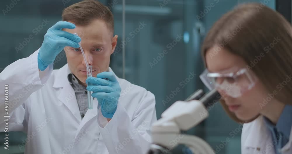 man and woman scientists are working in chemical laboratory, researching and experimenting with reagents