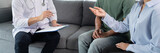 Asian doctor and couple looking and discussing over clipboard to marriage advice during a therapy sitting on a sofa at home.