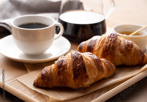 Croissants and coffee on a wooden tray