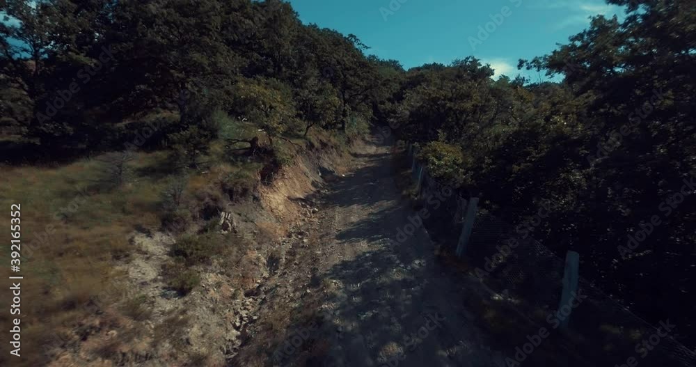 Drone starting point from a mountain raw road in national park or forest. Typical hills countryside landscape. Beautiful epic setting landscape of relaxing under blue sky Drone starting point from a mountain raw road in national park or forest. Typical hills countryside landscape. Beautiful epic setting landscape of relaxing under blue sky