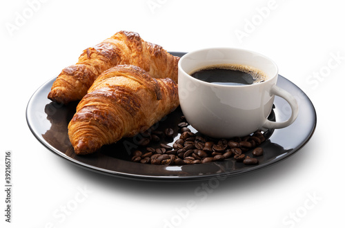 A croissant  coffee and coffee beans in a black dish on a white background