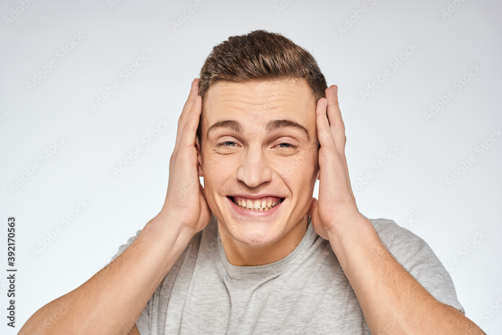 Cheerful emotional man gray t-shirt gesturing with hands studio lifestyle Cheerful emotional man gray t-shirt gesturing with hands studio lifestyle