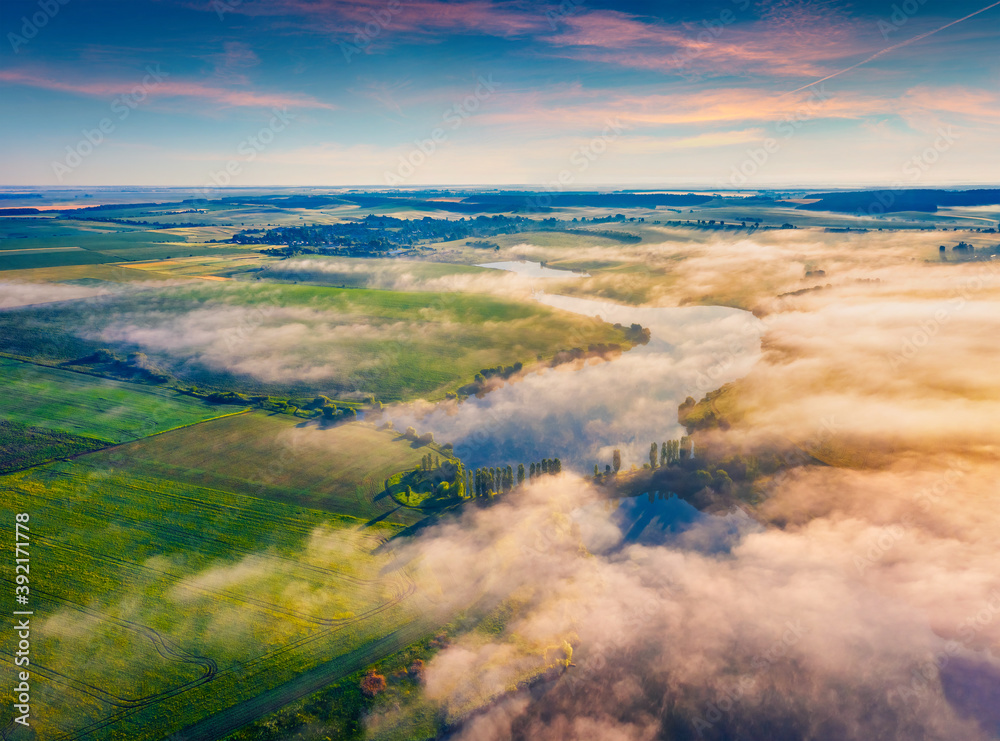 Fabulous summer scene of Ukrainian countryside, Ternopil region. View from flying drone of Angelivka lake. Foggy morning landscape on Ukraine, Europe. Traveling concept background.