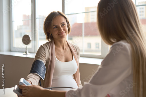 Doctor measuring blood pressure of her pregnant patient. High quality photo photo