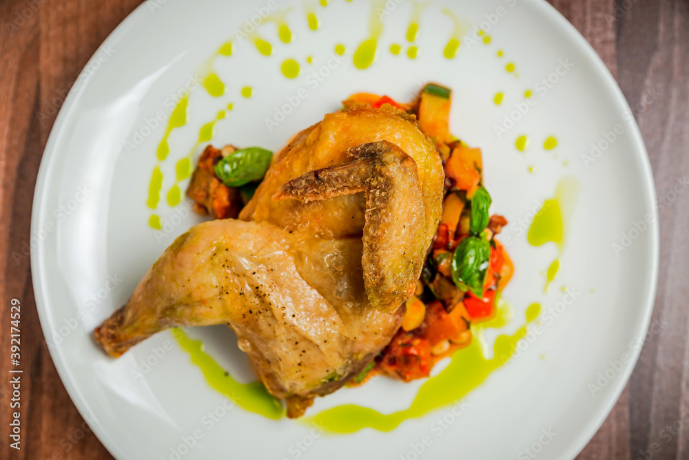 Half of the chicken with vegetable caponata, top view, close up Half of the chicken with vegetable caponata, top view, close up