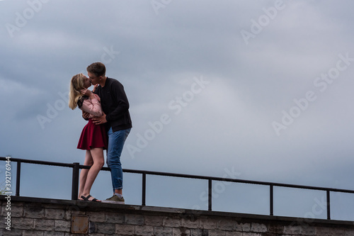 Beautiful loving each other couple is standing and kissing on on sky backgrounds