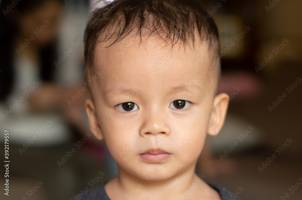 Portrait of an Asian boy standing still and looking at the camera. Portrait of an Asian boy standing still and looking at the camera.