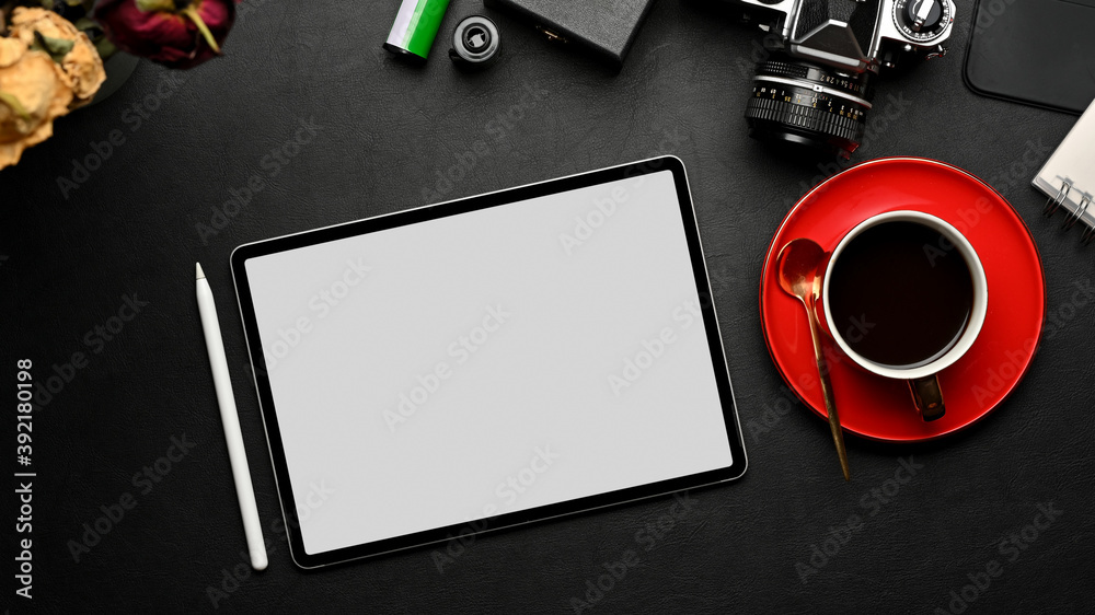 Workspace with tablet, coffee cup, camera and supplies on black table, clipping path Workspace with tablet, coffee cup, camera and supplies on black table, clipping path