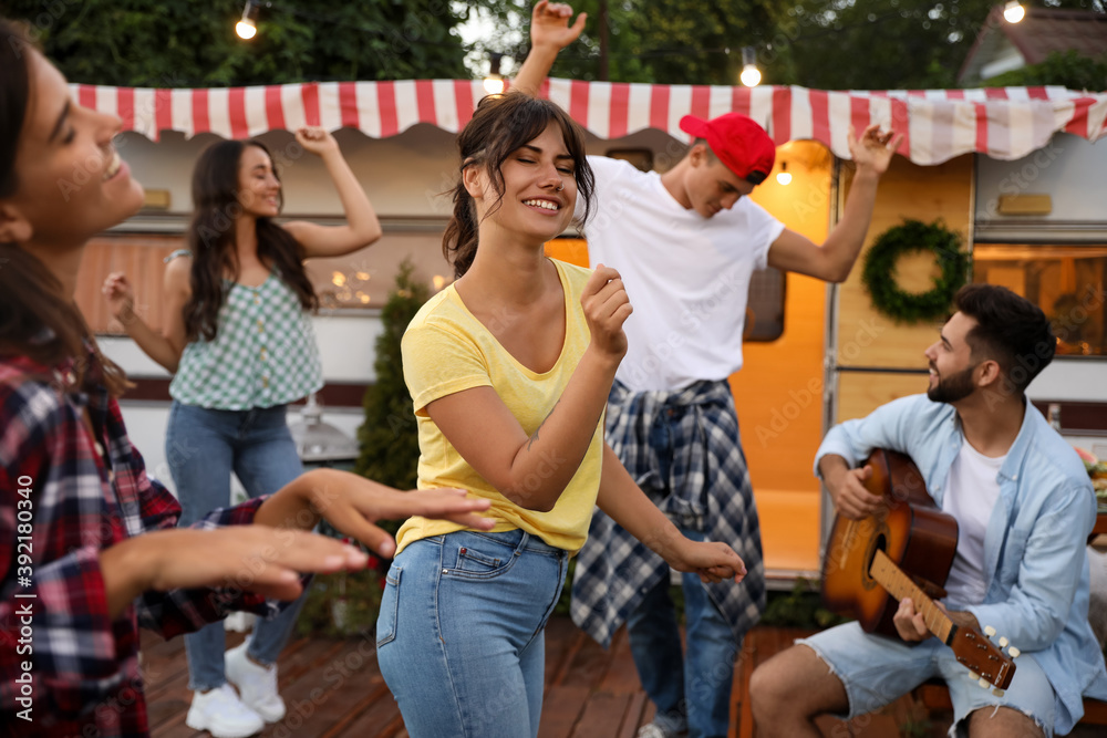 Fototapeta premium Happy friends having fun near trailer. Camping season