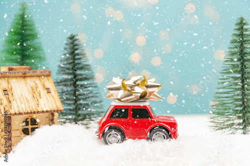 Christmas or New year card with toy car and christmas tree miniature and Christmas bokeh lights on background © IKvyatkovskaya