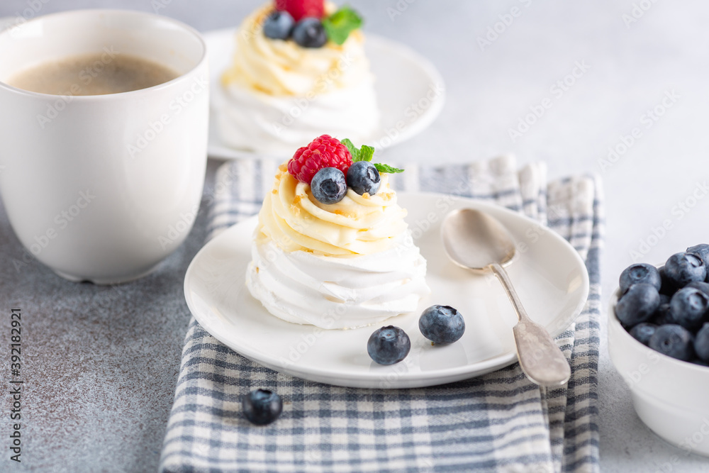 New Zealand Pavlova cake with whipped cream and fresh berries and mug with coffee New Zealand Pavlova cake with whipped cream and fresh berries and mug with coffee