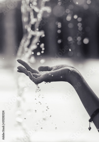beautiful hand under rain drops of water black and white style closeup