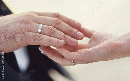 Hands of groom and bride at wedding day. Bridal couple hugging. Wedding love and family concept close up macro photo with selective focus