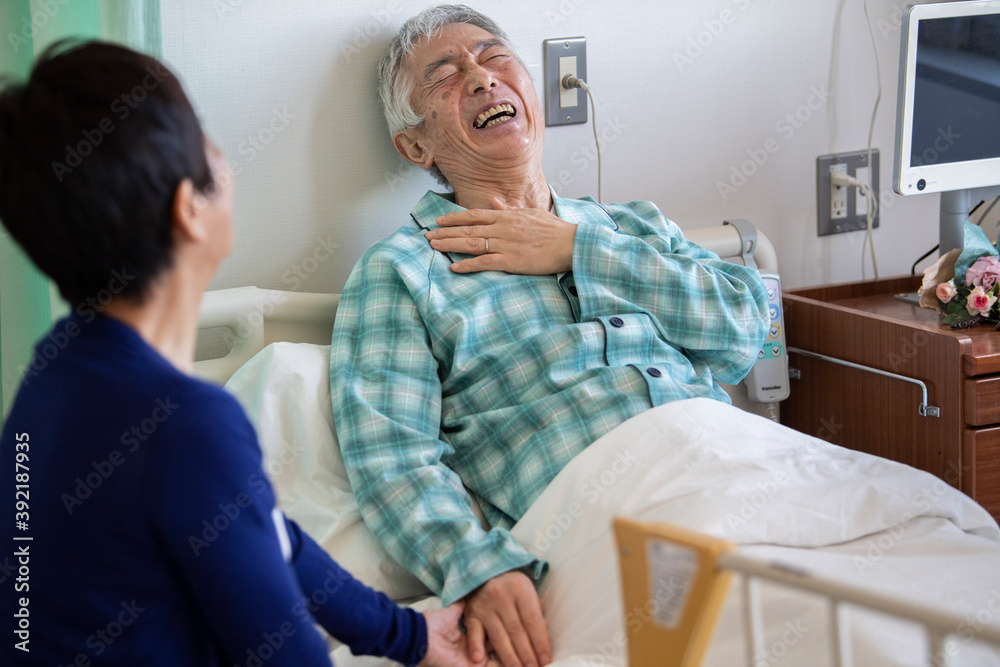 Obraz premium 入院中の高齢男性とその妻 回診に来た医師、女性看護師