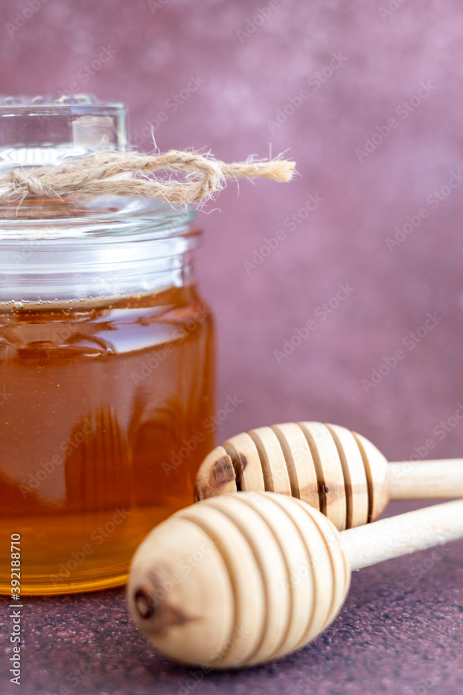 Glass can full of honey and wooden stick Glass can full of honey and wooden stick