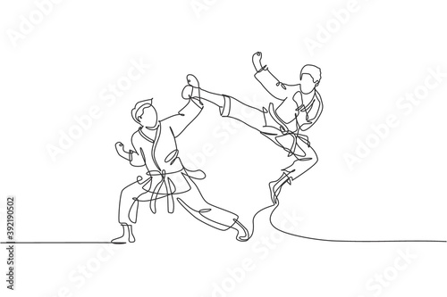 Single continuous line drawing of young confident karateka man in kimono practicing karate combat at dojo. Martial art sport training concept. Trendy one line draw design vector graphic illustration