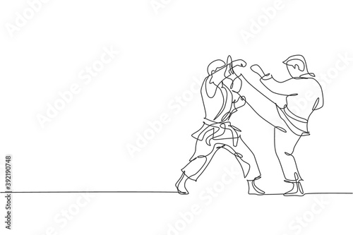 One single line drawing of two young sporty karateka men in fight uniform with belt exercising martial art at gym vector illustration. Healthy sport lifestyle concept. Modern continue line draw design