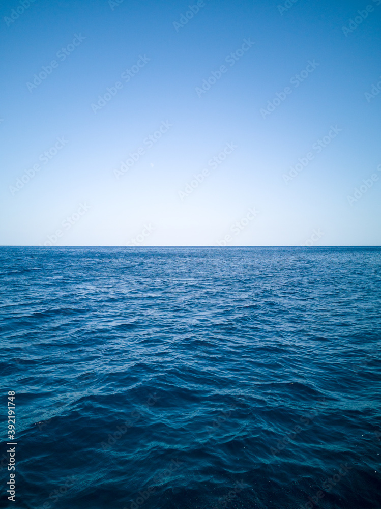 Blue ocean water and sky straight horizon line
