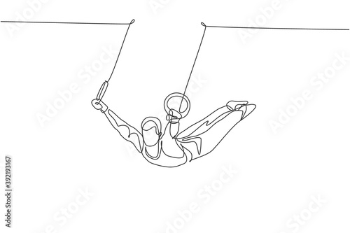 Single continuous line drawing young handsome professional gymnast man perform acrobatic motion. Steady rings training and stretching concept. Trendy one line draw design graphic vector illustration