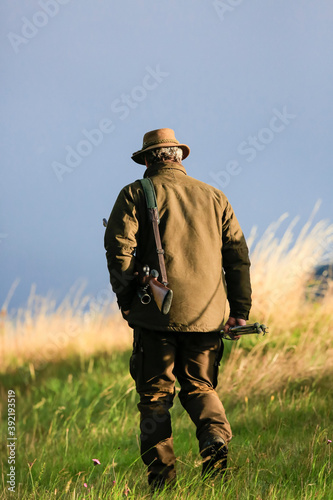 Hunter in traditional clothes with a rifle in the autumn hunting season.