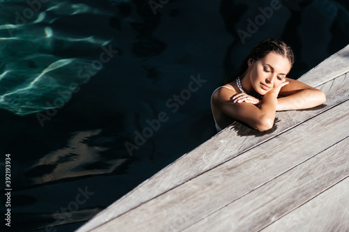 beautiful long hair female model posing by the pool, outdoor portrait Bali Indonesia