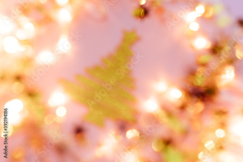 Blurred Golden star sprinkles on pink. Festive holiday background. Celebration concept. Top view, flat lay. Horizontal