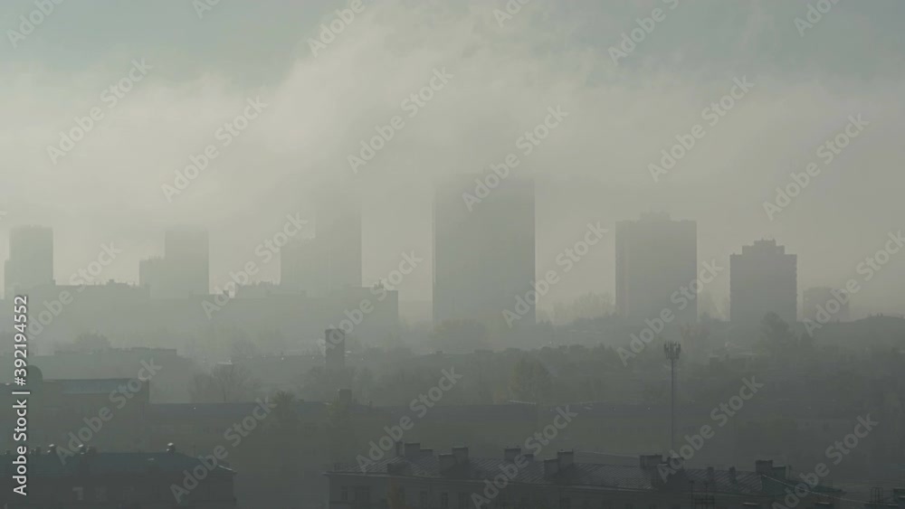 louds of fog enveloped the tall buildings. Residential high-rise buildings in the fog. Tall houses stand in a row in the fog. louds of fog enveloped the tall buildings. Residential high-rise buildings in the fog. Tall houses stand in a row in the fog.