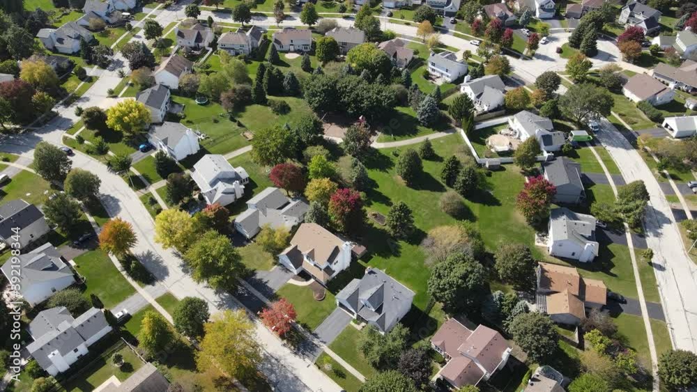 Overhead aerial view of colorful autumn trees residential houses and yards along suburban street in Chicago area. Midwest USA. 4K
