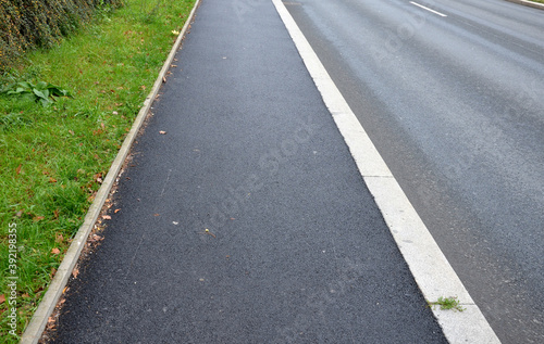 soundproof wall made of wooden slat concrete fence made of gray blocks on the street. noise from road traffic does not get into the garden, park. sidewalk of beige fine gravel asphalt surface  photo