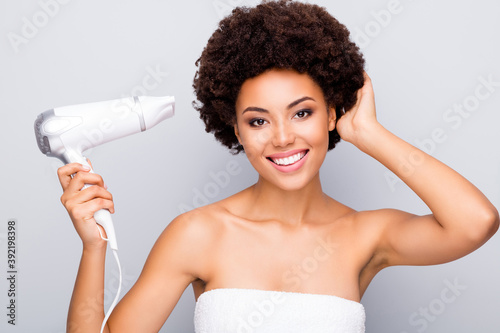 Close-up portrait of her she nice-looking cheerful cheery attractive wavy-haired girl using dryer drying hair in the morning isolated on light white gray color pastel background