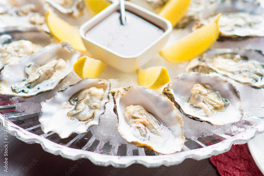 Fresh oysters in a white plate with ice and lemon Fresh oysters in a white plate with ice and lemon