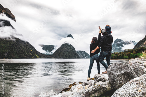 Happy Travel family in Milford Sound, New Zealand. Couple with his kid enjoying the view in Mildford Sound. photo