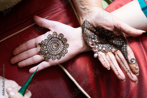 Top down video of a woman copying the mehndi henna tattoo from one hand to the other in preparation of the hindu festival of teej, karwachauth, diwali dussera or a marriage function