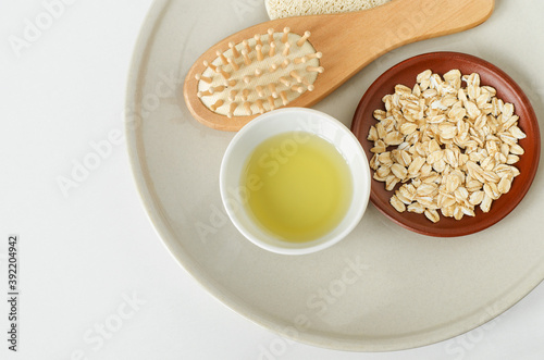 Olive oil, oatmeal and wooden hairbrush. Natural beauty treatment and zero waste concept. Top view, copy space.