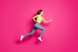 Full body profile side photo of girl jump run fast look empty space wear casual outfit jeans isolated over pink color background