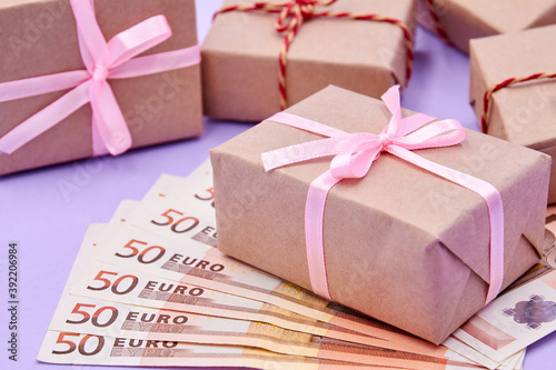 Christmas or New Year gift box on euros against a background of boxes. Money as a gift for Christmas