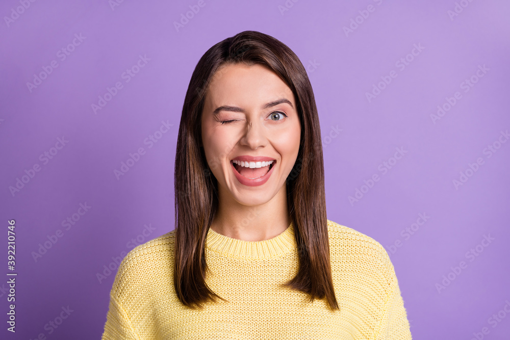 Photo portrait of winking young girl with closed eye smiling isolated on bright color purple background Photo portrait of winking young girl with closed eye smiling isolated on bright color purple background
