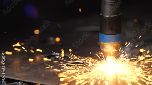 Work in the workshop for  manufacture of tin products. Close up detil sho of cnc plasma machine cutting a hole in sheet metal. Sparks scatter beautifully in different directions. 200 fps slow motion photo