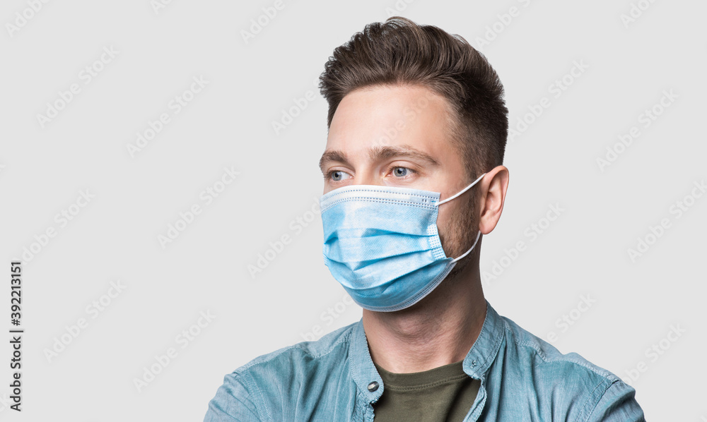 Young man wearing protective face mask studio isolated portrait, social distancing, pandemic, corona virus protection, healthy lifestyle, people concept