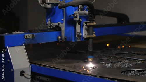 Work in the workshop for the manufacture of tin products. A cnc plasma machine cutting a hole in sheet metal. Sparks scatter beautifully in different directions. 200 fps slow motion photo