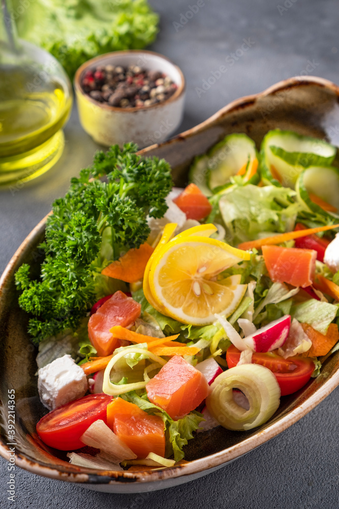 Salmon salad with fresh vegetables and cheese. Closeup