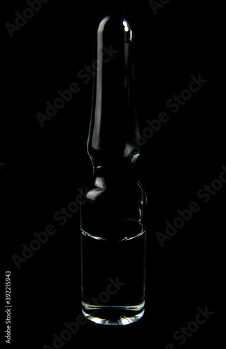 An ampoule of medicine on a black background. Vaccine. © Viktor