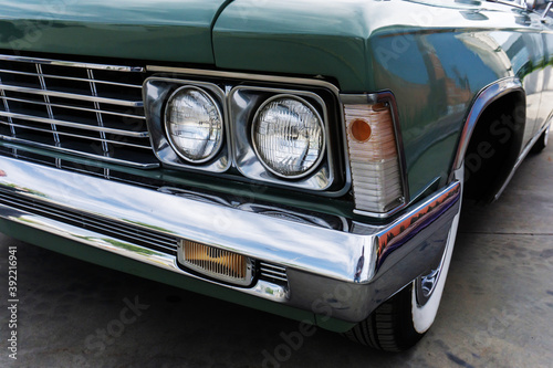 Fragment of a retro car with round headlights. Close-up
