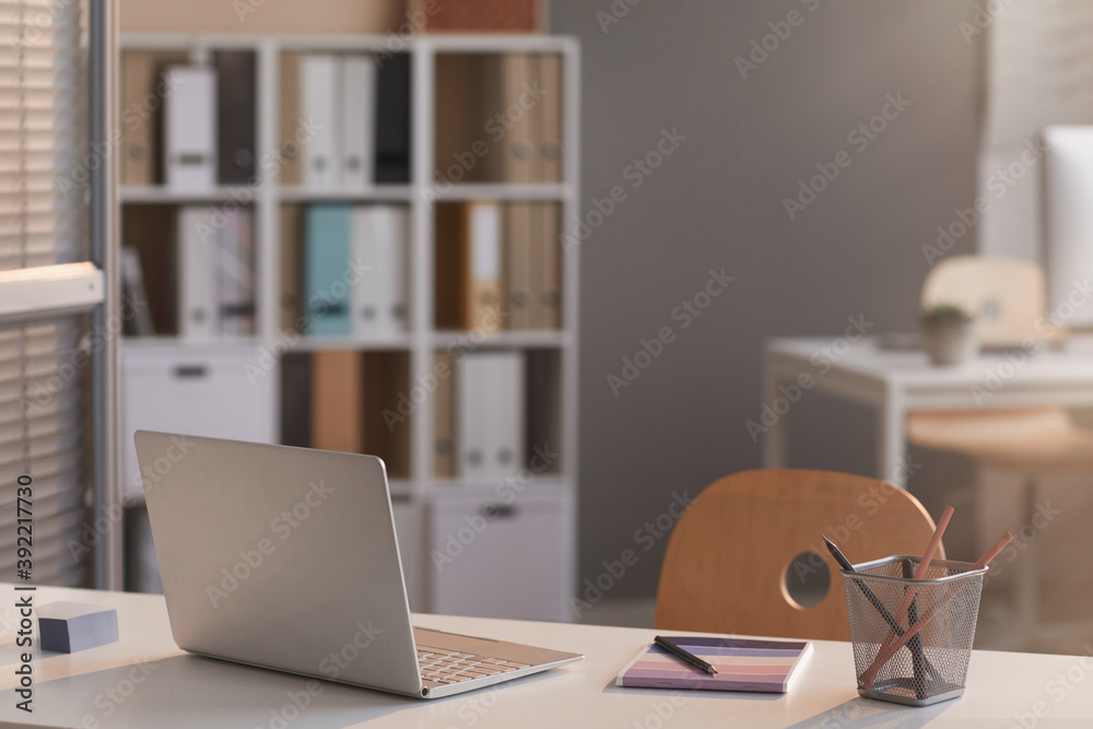 Image of laptop on empty desk at modern empty office Image of laptop on empty desk at modern empty office