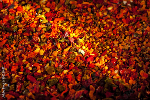 A mixture of different spices close up. Textures of colorful spices and condiments. Contrasting dramatic light as an artistic effect.