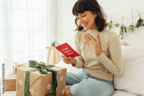 Happy woman reading a christmas greeting card photo