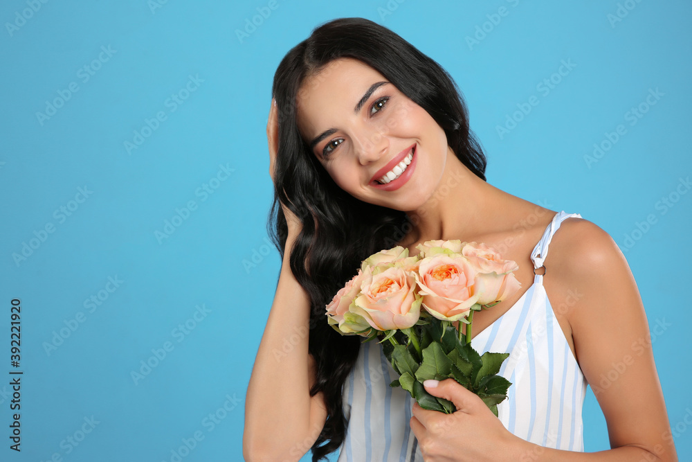 Portrait of smiling woman with beautiful bouquet on light blue background Portrait of smiling woman with beautiful bouquet on light blue background