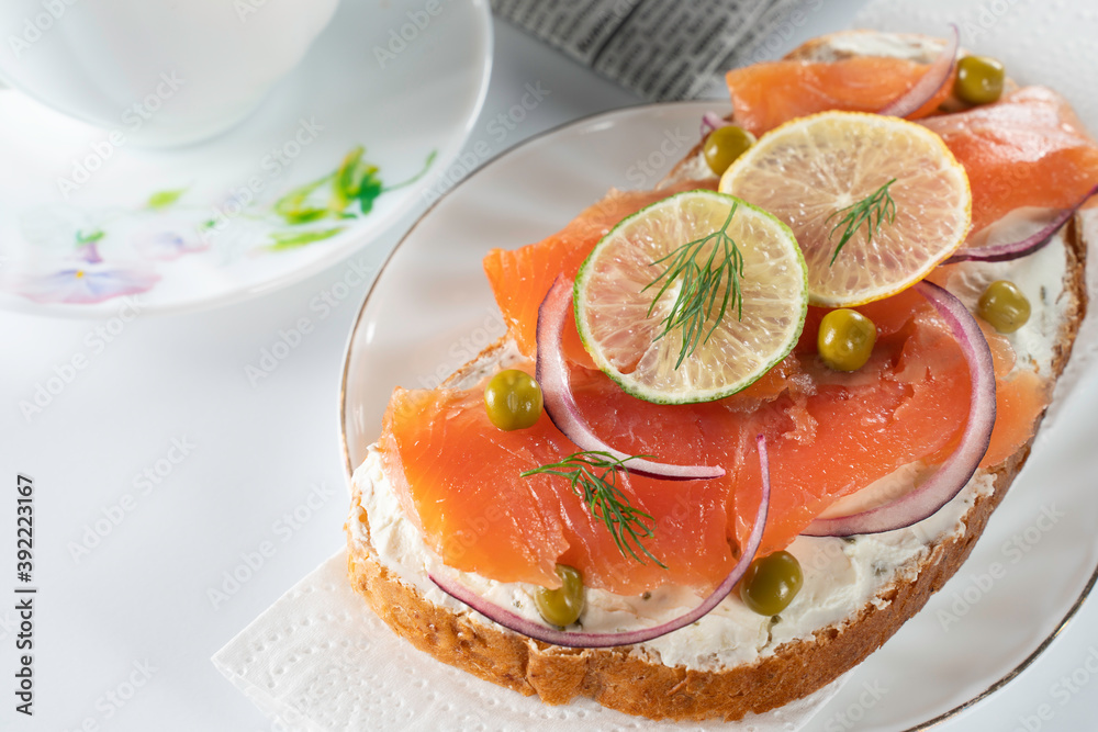 sandwich with salmon slices, fresh herbs, lemon and lime slices sandwich with salmon slices, fresh herbs, lemon and lime slices